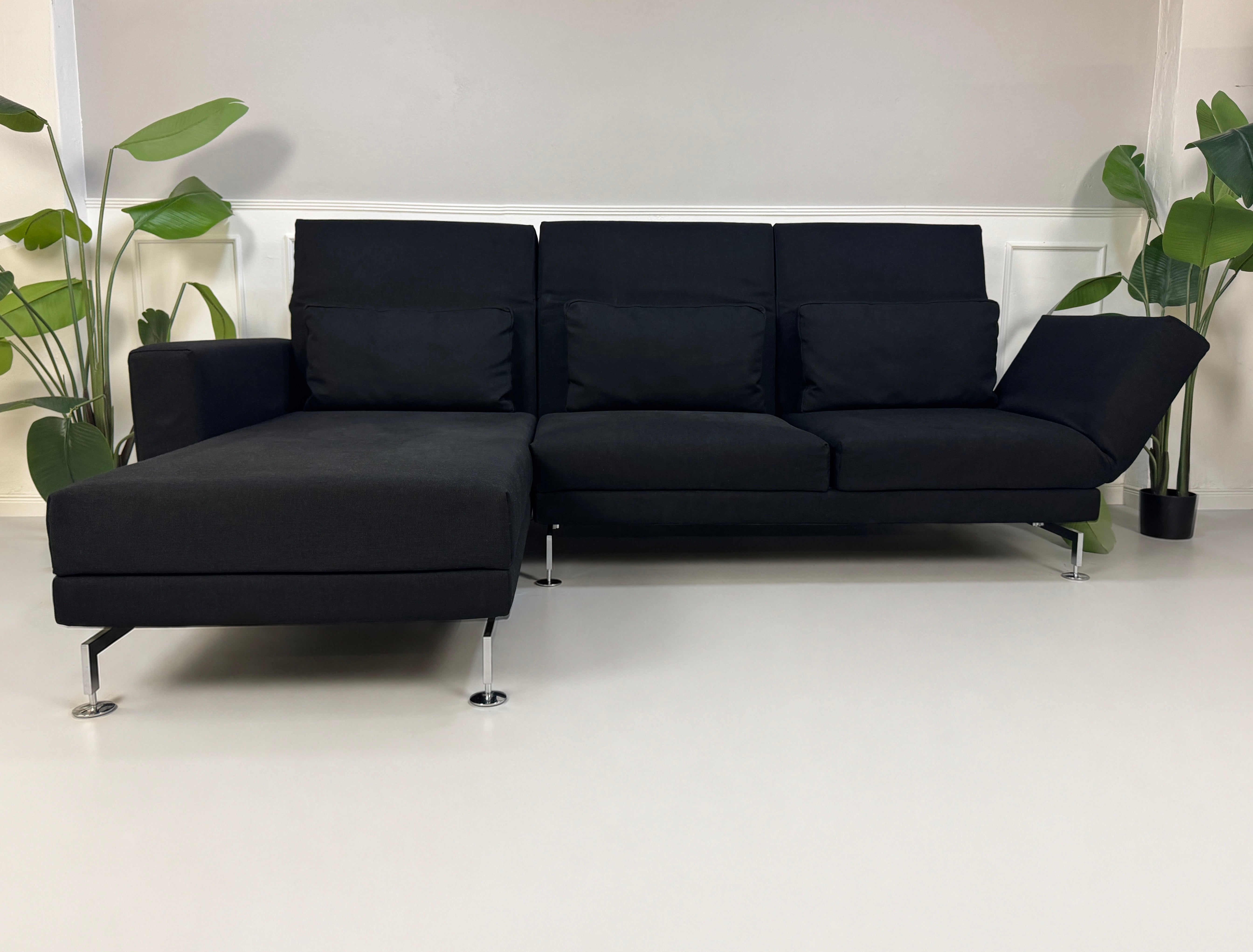 Gebrauchtes schwarzes Brühl Moule Designer Stoff Sofa vor einer Wand, stilvoll und modern eingerichtet.