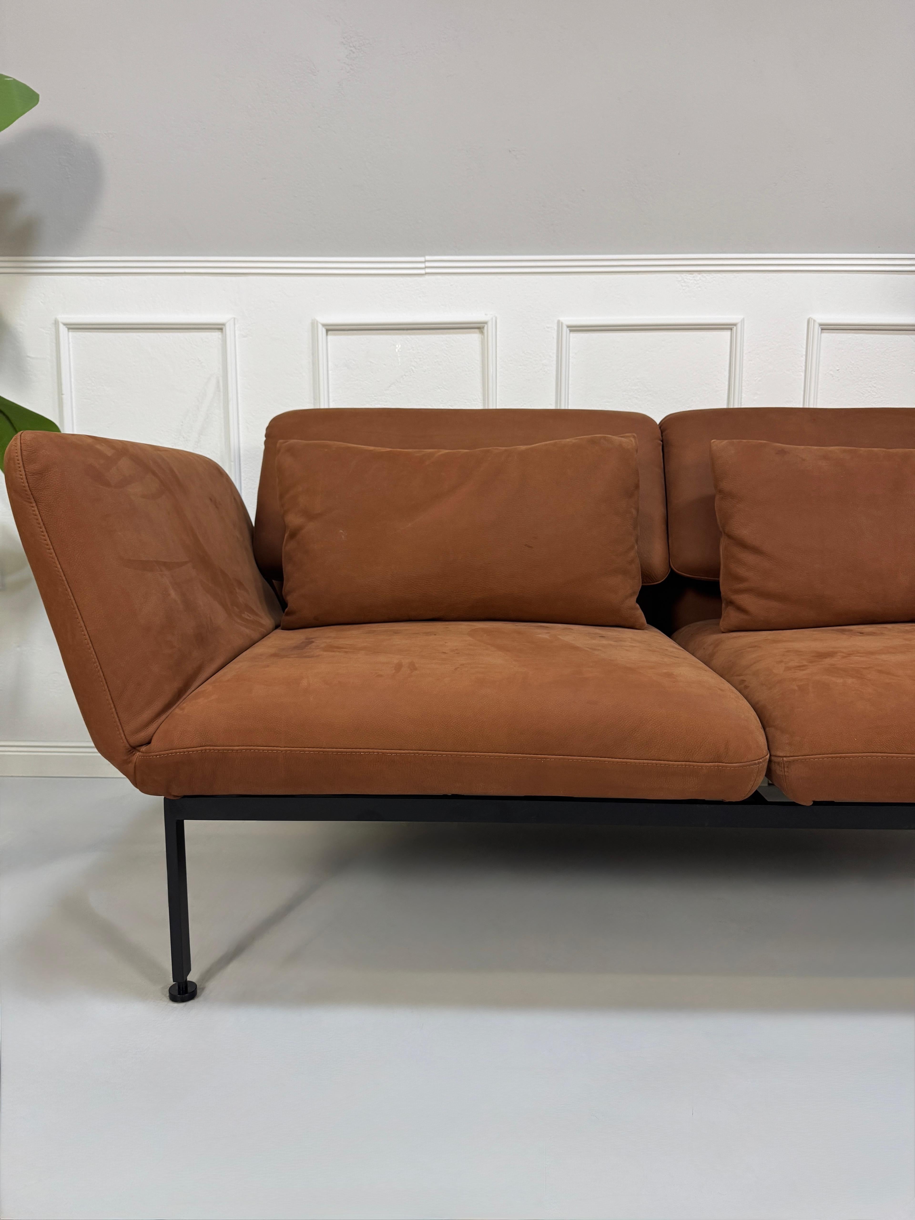 Gebrauchtes braunes Brühl Roro Designer Leder Taron Sofa vor einer Wand, stilvoll und modern eingerichtet.