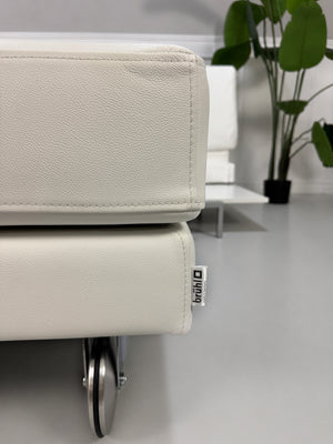 Ausstellungsstück weißes Brühl FourTwo  Designer Leder Sofa vor einer Wand, stilvoll und modern eingerichtet.