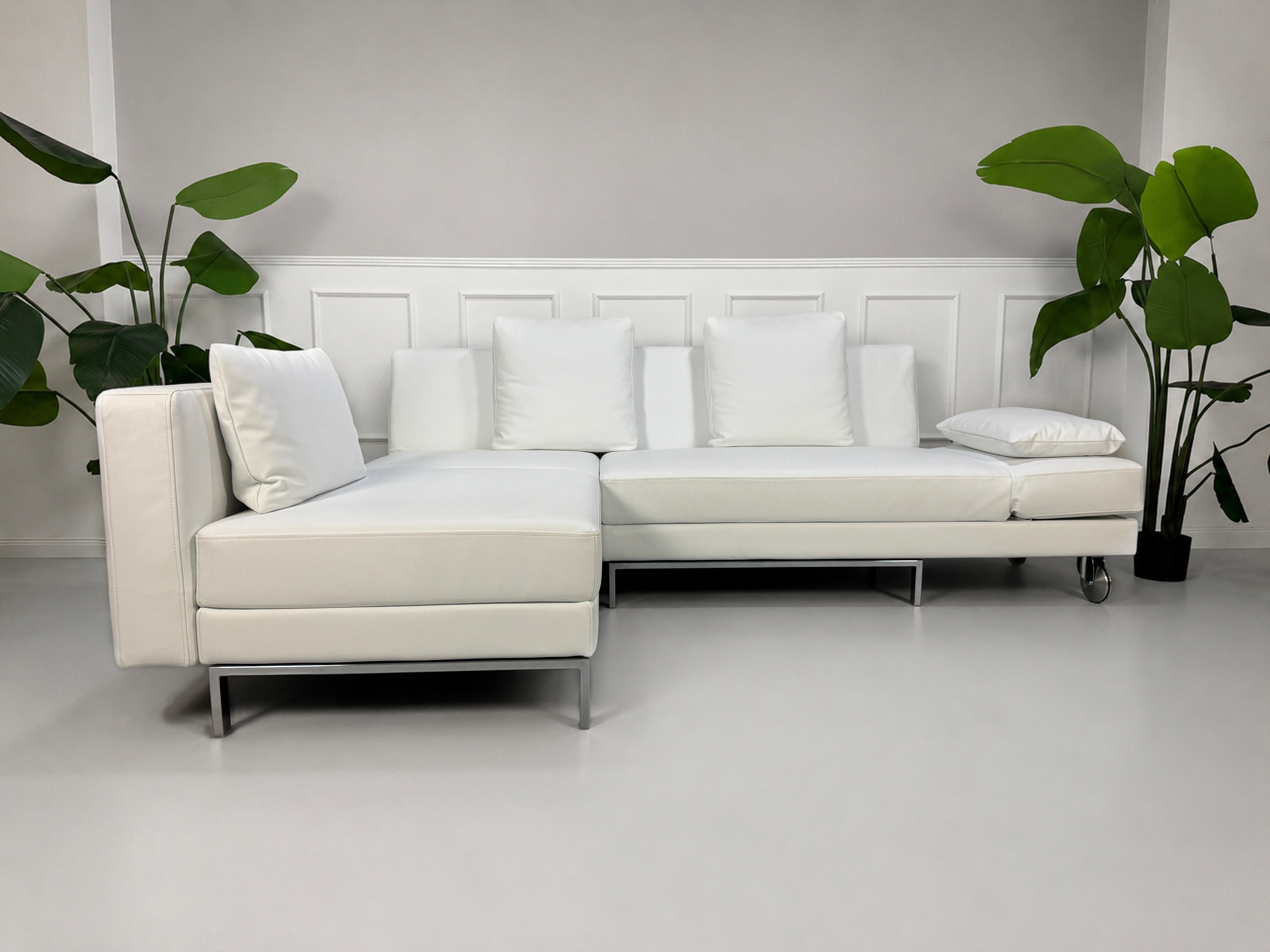Ausstellungsstück weißes Brühl FourTwo  Designer Leder Sofa vor einer Wand, stilvoll und modern eingerichtet.