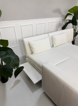 Ausstellungsstück weißes Brühl FourTwo  Designer Leder Sofa vor einer Wand, stilvoll und modern eingerichtet.