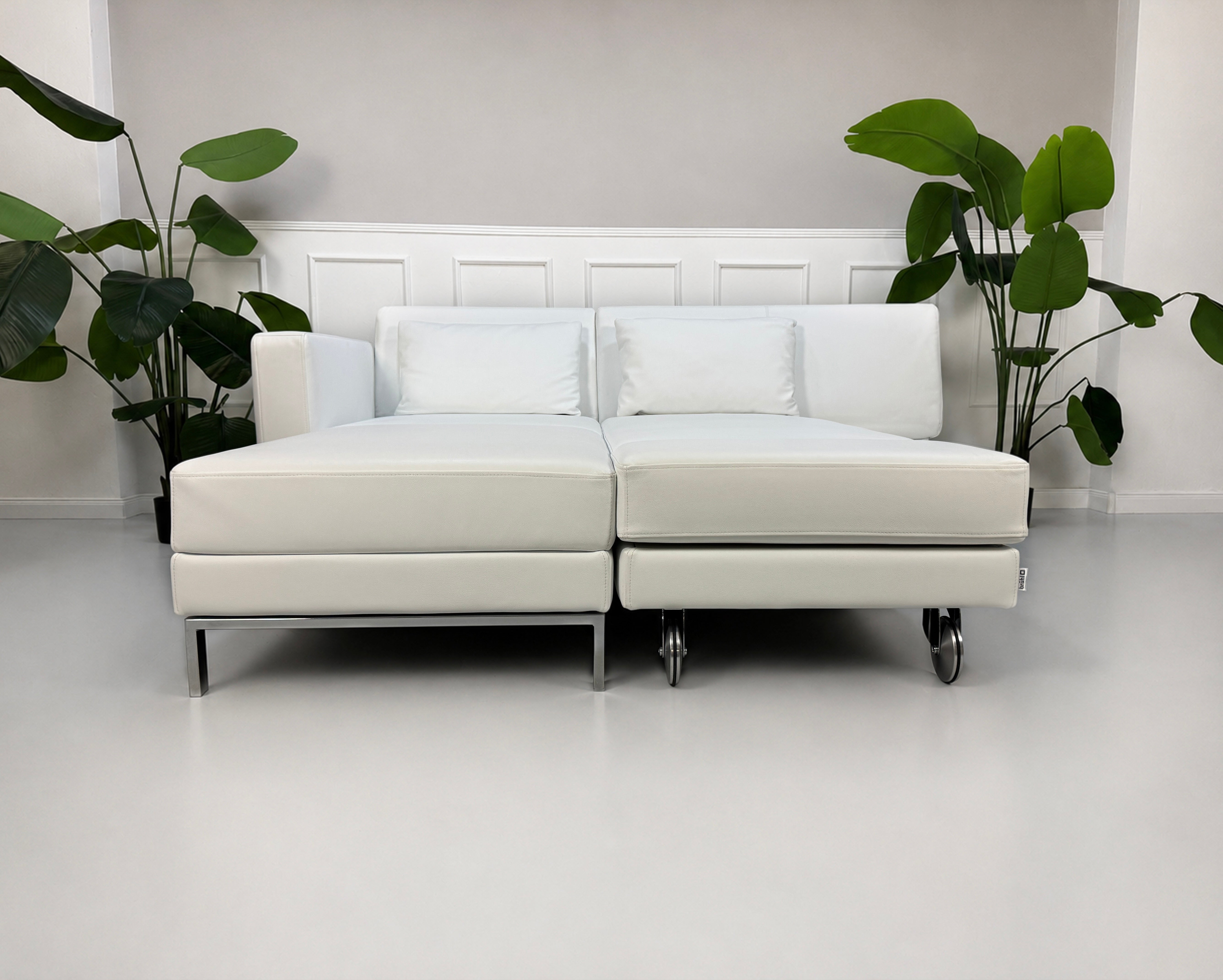 Ausstellungsstück weißes Brühl FourTwo  Designer Leder Sofa vor einer Wand, stilvoll und modern eingerichtet.