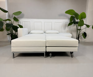 Ausstellungsstück weißes Brühl FourTwo  Designer Leder Sofa vor einer Wand, stilvoll und modern eingerichtet.
