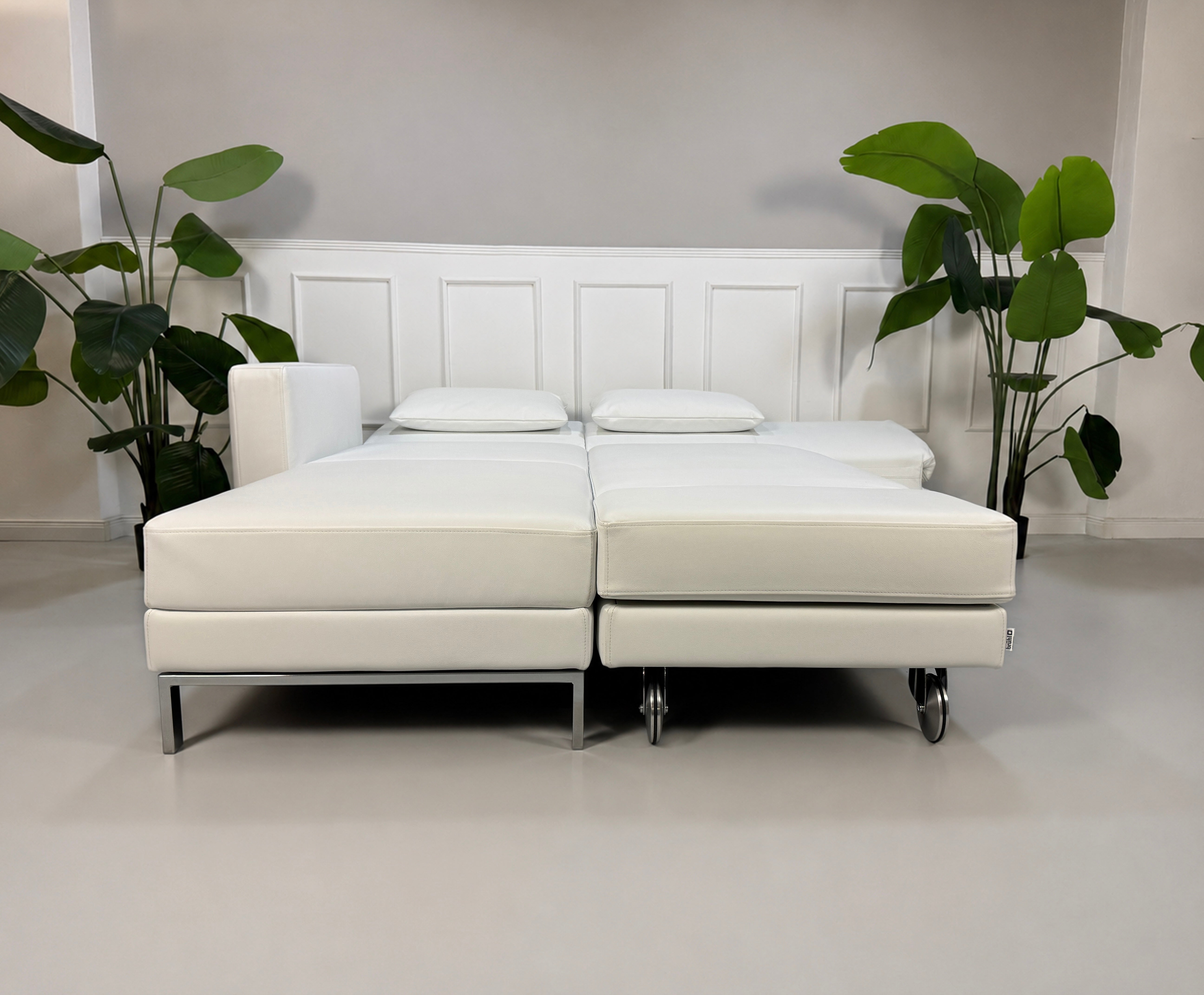 Ausstellungsstück weißes Brühl FourTwo  Designer Leder Sofa vor einer Wand, stilvoll und modern eingerichtet.