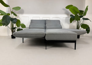Gebrauchtes graues Rolf Benz Mera Designer Stoff Sofa vor einer Wand, stilvoll und modern eingerichtet.