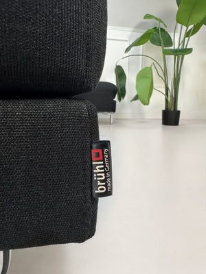 Gebrauchtes schwarzes Brühl Fourtwo Designer Stoff Sofa vor einer Wand, stilvoll und modern eingerichtet.