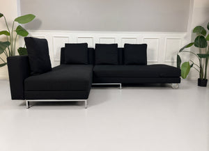 Gebrauchtes schwarzes Brühl Fourtwo Designer Stoff Sofa vor einer Wand, stilvoll und modern eingerichtet.