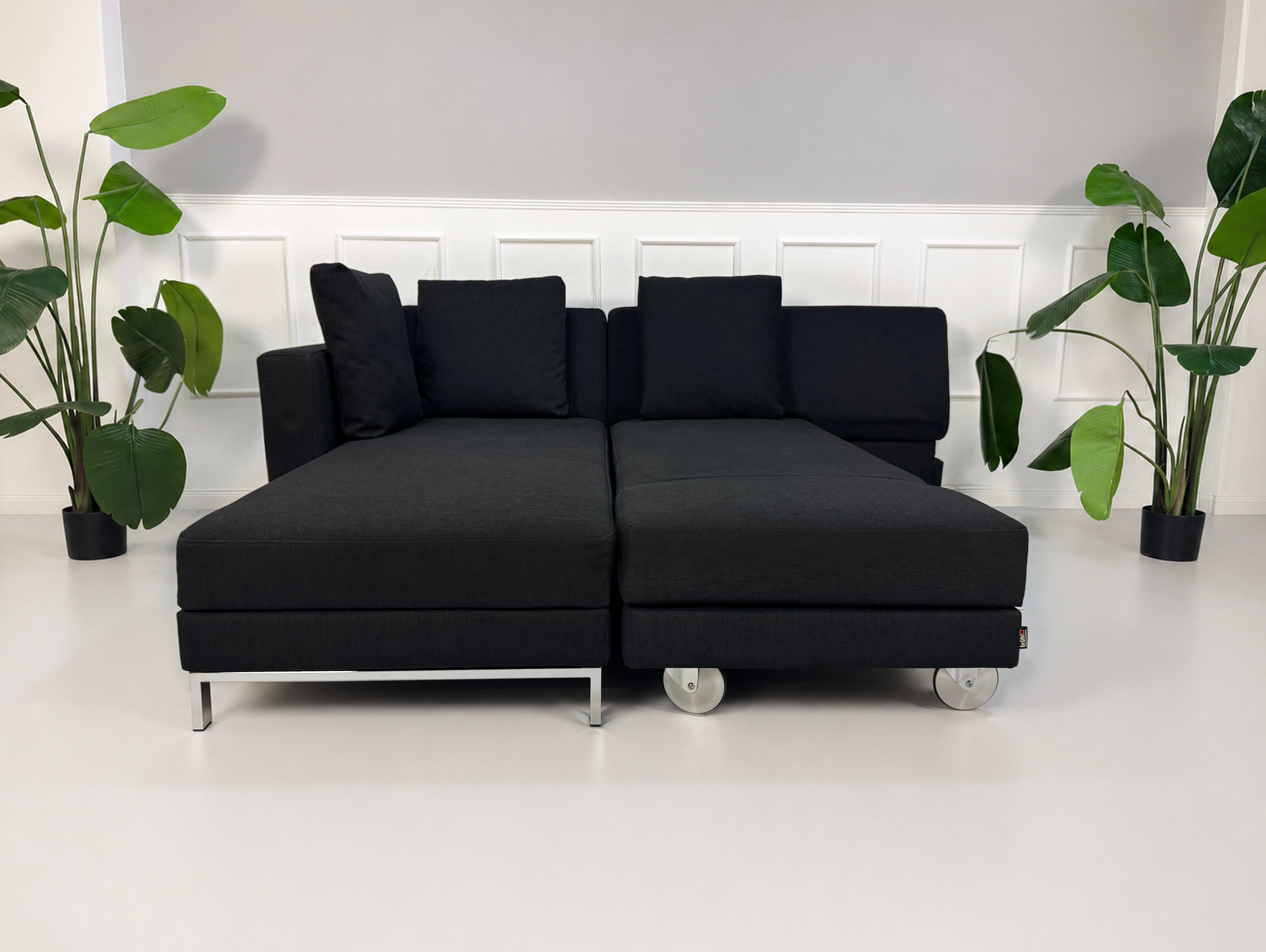 Gebrauchtes schwarzes Brühl Fourtwo Designer Stoff Sofa vor einer Wand, stilvoll und modern eingerichtet.