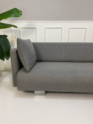 Gebrauchtes graues Rolf Benz 6300 Designer Stoff Sofa vor einer Wand, stilvoll und modern eingerichtet.