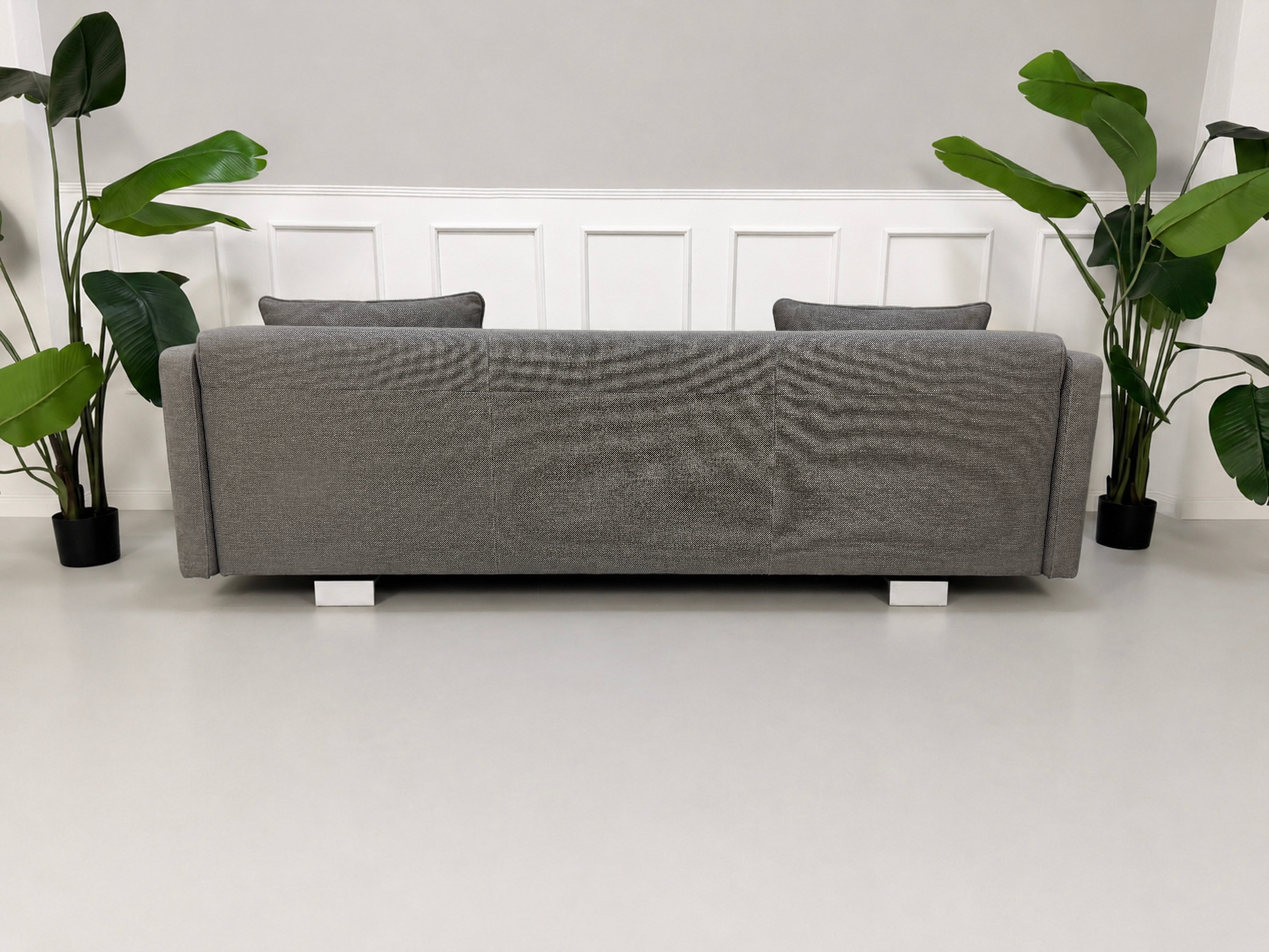 Gebrauchtes graues Rolf Benz 6300 Designer Stoff Sofa vor einer Wand, stilvoll und modern eingerichtet.