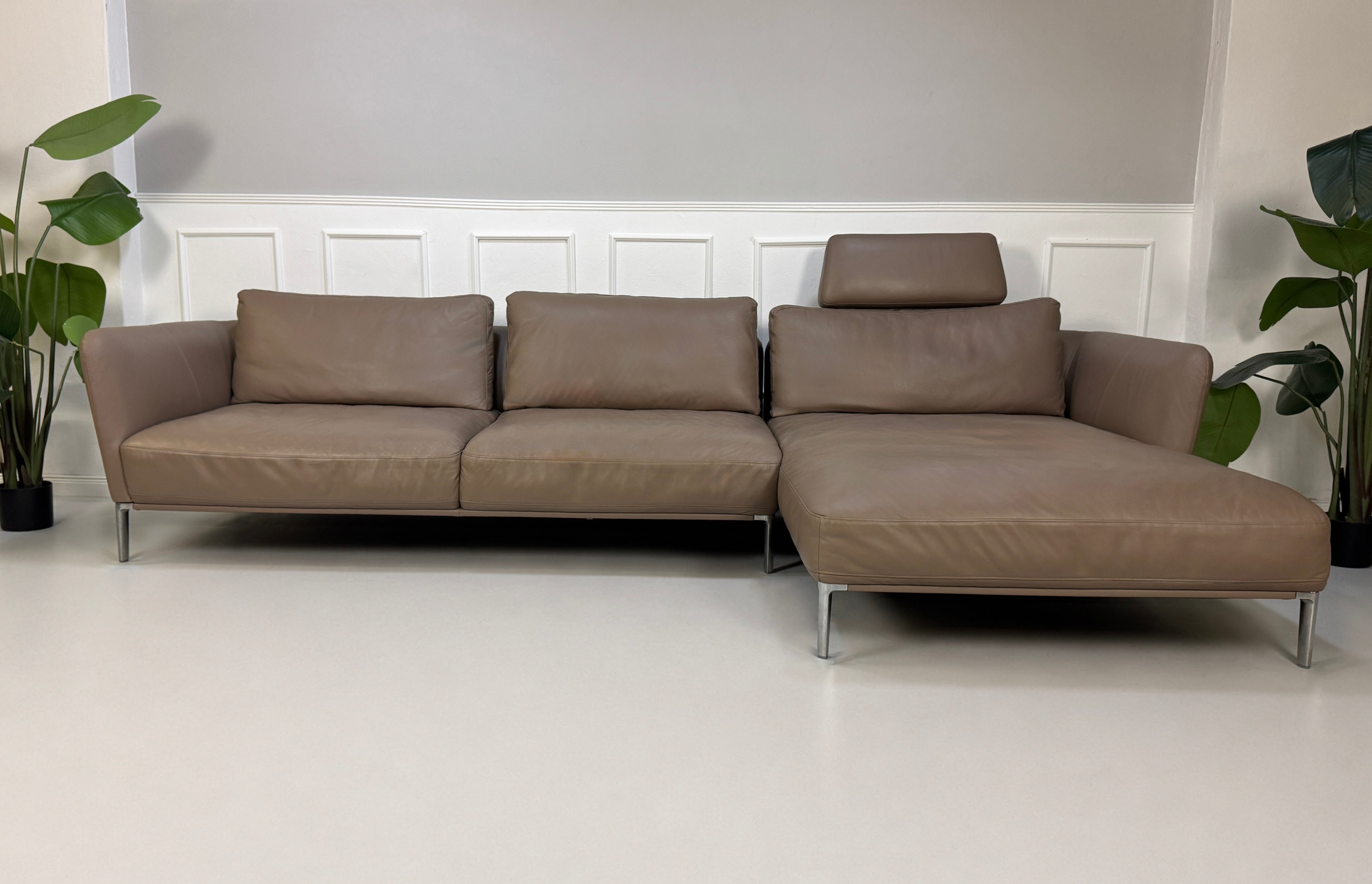 Gebrauchtes Braun Grau Rolf Benz Scala Designer Leder Sofa vor einer Wand, stilvoll und modern eingerichtet.