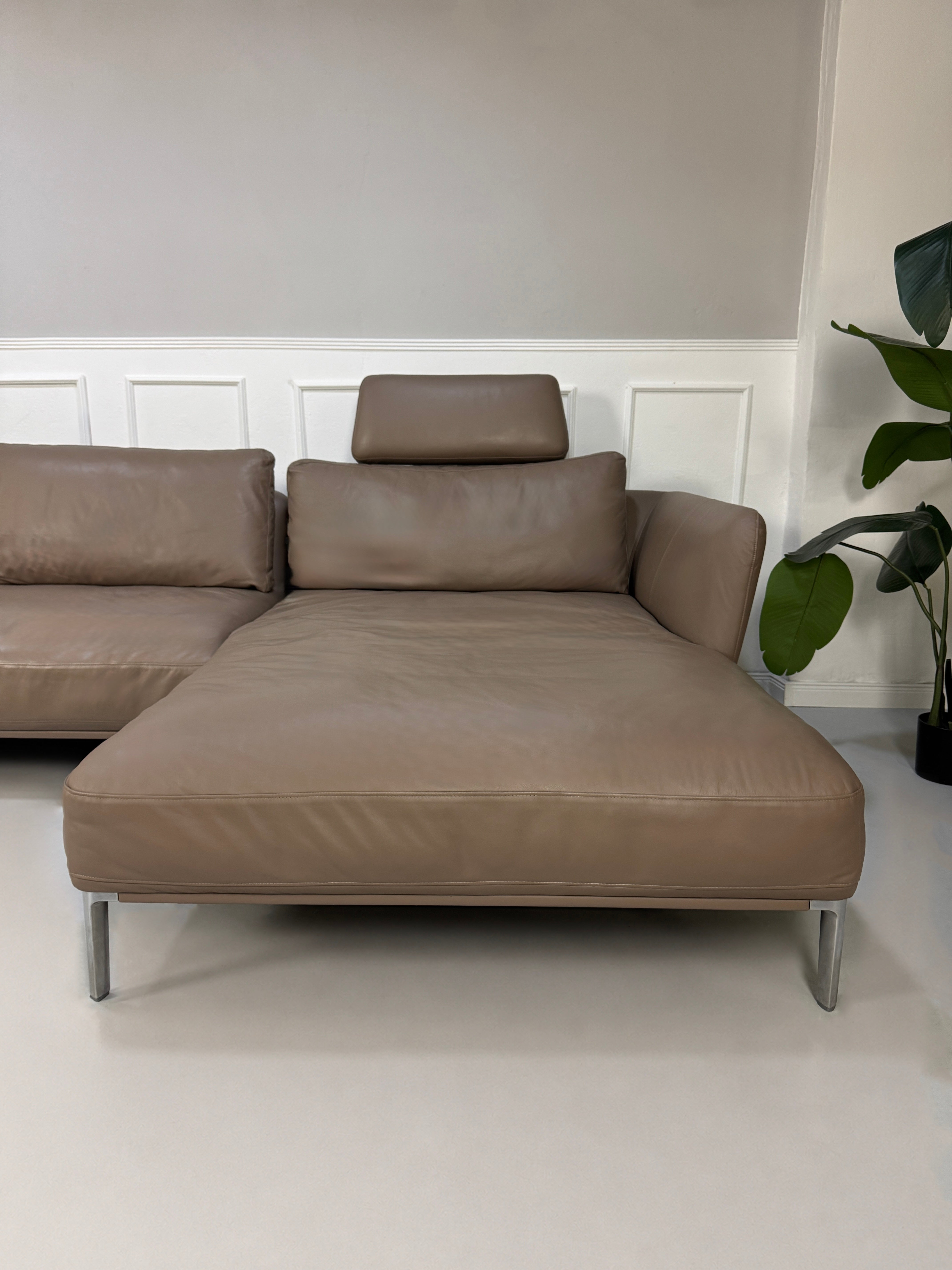 Gebrauchtes Braun Grau Rolf Benz Scala Designer Leder Sofa vor einer Wand, stilvoll und modern eingerichtet.