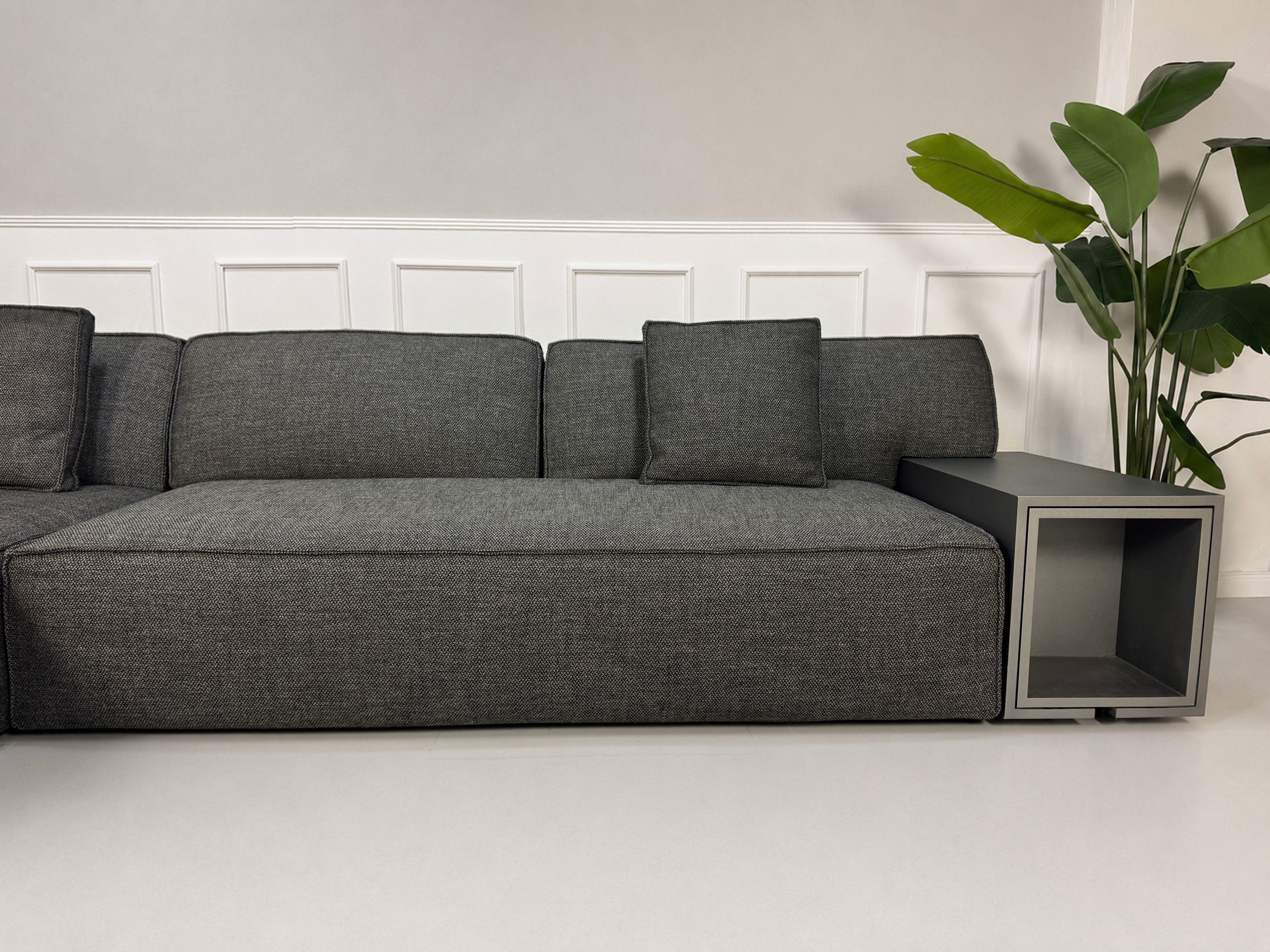 Gebrauchtes graues Cassina 244 My World Designer Stoff Sofa vor einer Wand, stilvoll und modern eingerichtet.