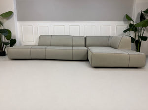 Gebrauchtes graues BB Italia Bend Designer Stoff Sofa vor einer Wand, stilvoll und modern eingerichtet.