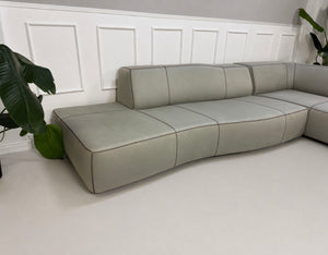 Gebrauchtes graues BB Italia Bend Designer Stoff Sofa vor einer Wand, stilvoll und modern eingerichtet.