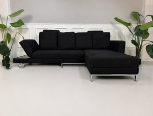 Gebrauchtes schwarzes Brühl Fourtwo Designer Stoff Sofa vor einer Wand, stilvoll und modern eingerichtet.