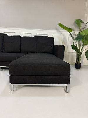 Gebrauchtes schwarzes Brühl Fourtwo Designer Stoff Sofa vor einer Wand, stilvoll und modern eingerichtet.