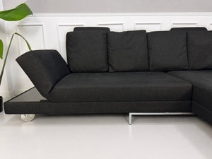 Gebrauchtes schwarzes Brühl Fourtwo Designer Stoff Sofa vor einer Wand, stilvoll und modern eingerichtet.