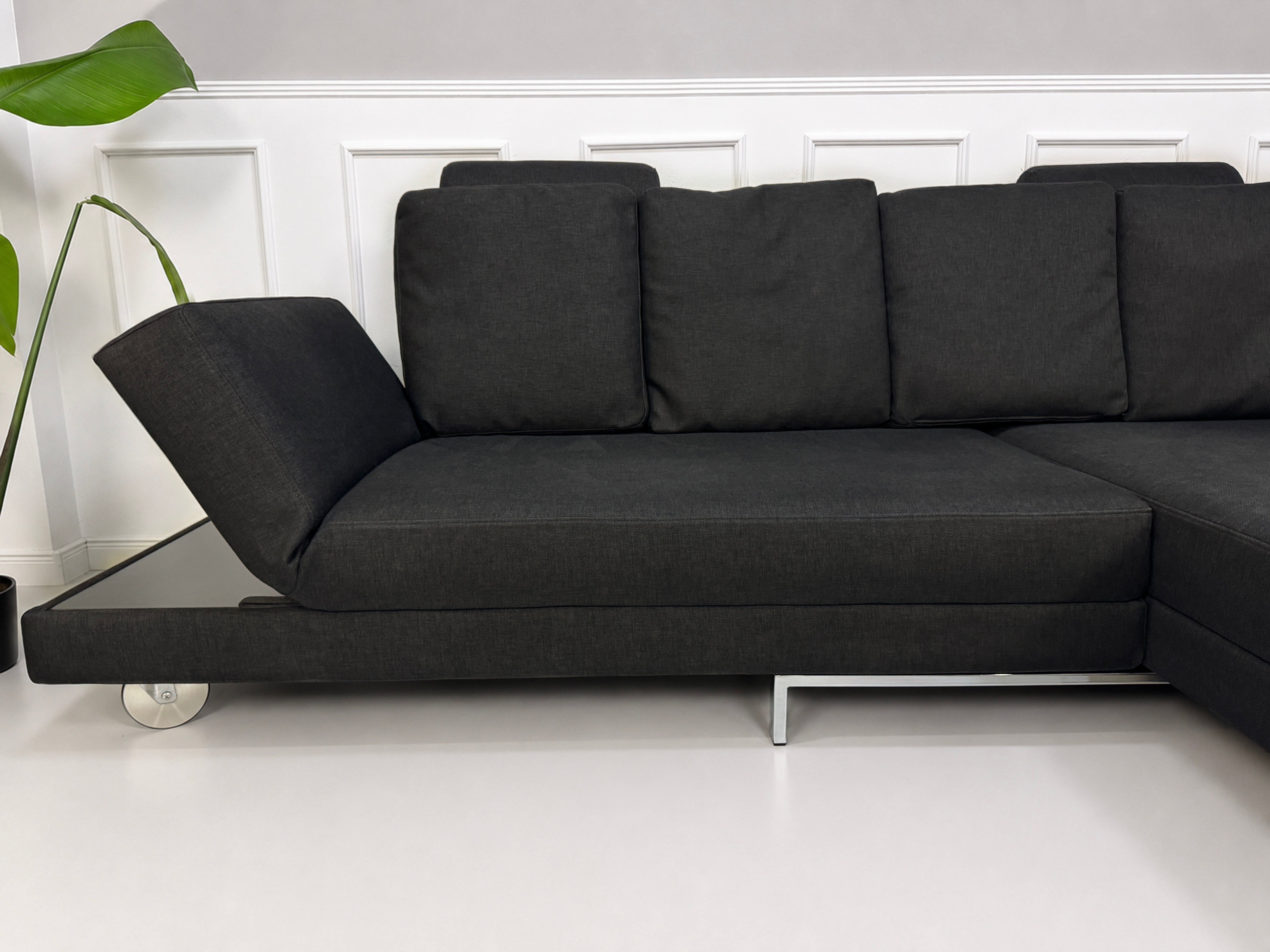 Gebrauchtes schwarzes Brühl Fourtwo Designer Stoff Sofa vor einer Wand, stilvoll und modern eingerichtet.