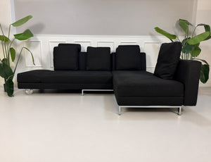Gebrauchtes schwarzes Brühl Fourtwo Designer Stoff Sofa vor einer Wand, stilvoll und modern eingerichtet.