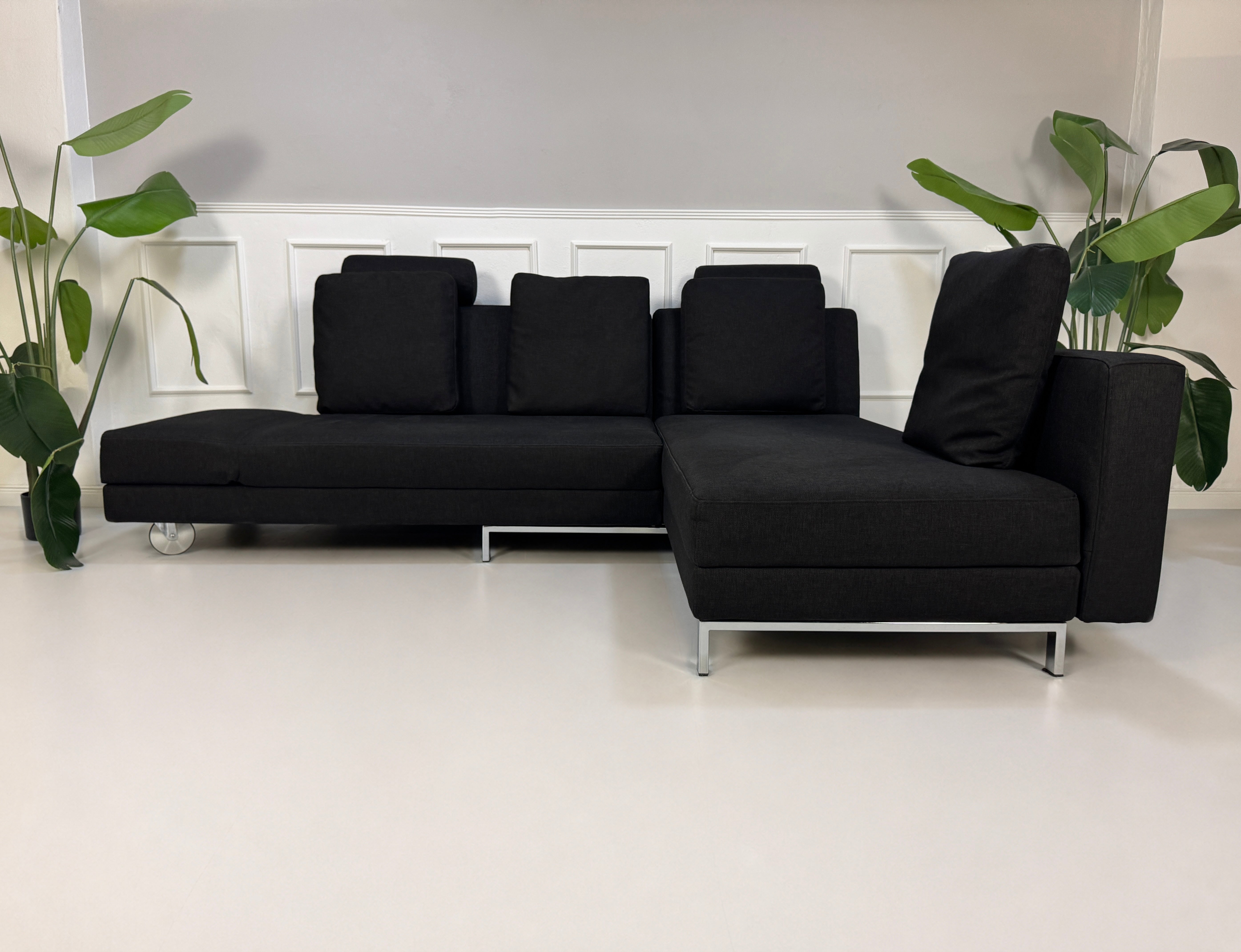 Gebrauchtes schwarzes Brühl Fourtwo Designer Stoff Sofa vor einer Wand, stilvoll und modern eingerichtet.