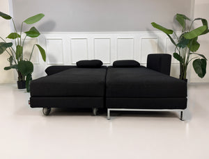 Gebrauchtes schwarzes Brühl Fourtwo Designer Stoff Sofa vor einer Wand, stilvoll und modern eingerichtet.