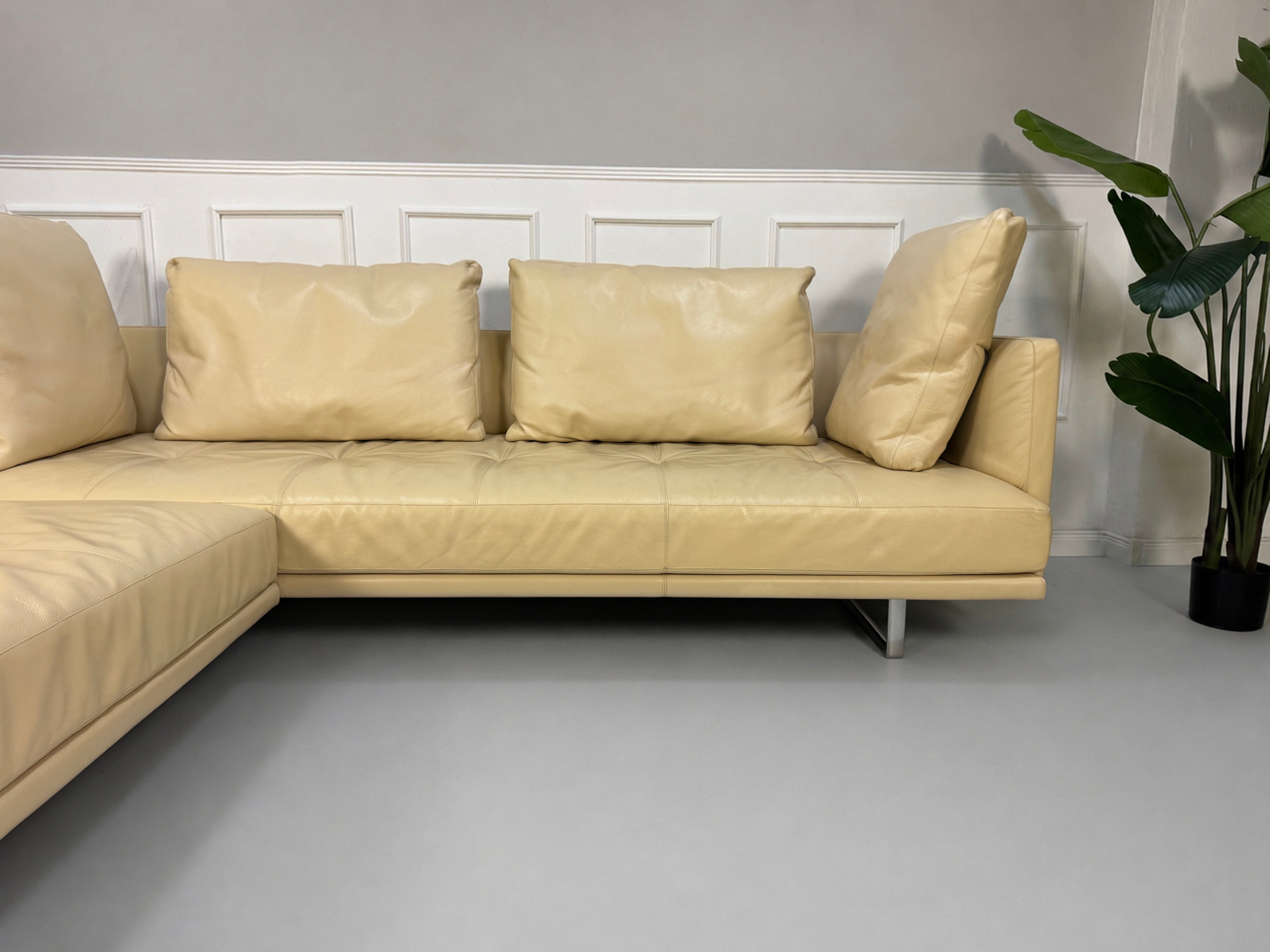 Gebrauchtes beiges Walter Knoll Prime Time Designer Leder Sofa vor einer Wand, stilvoll und modern eingerichtet.