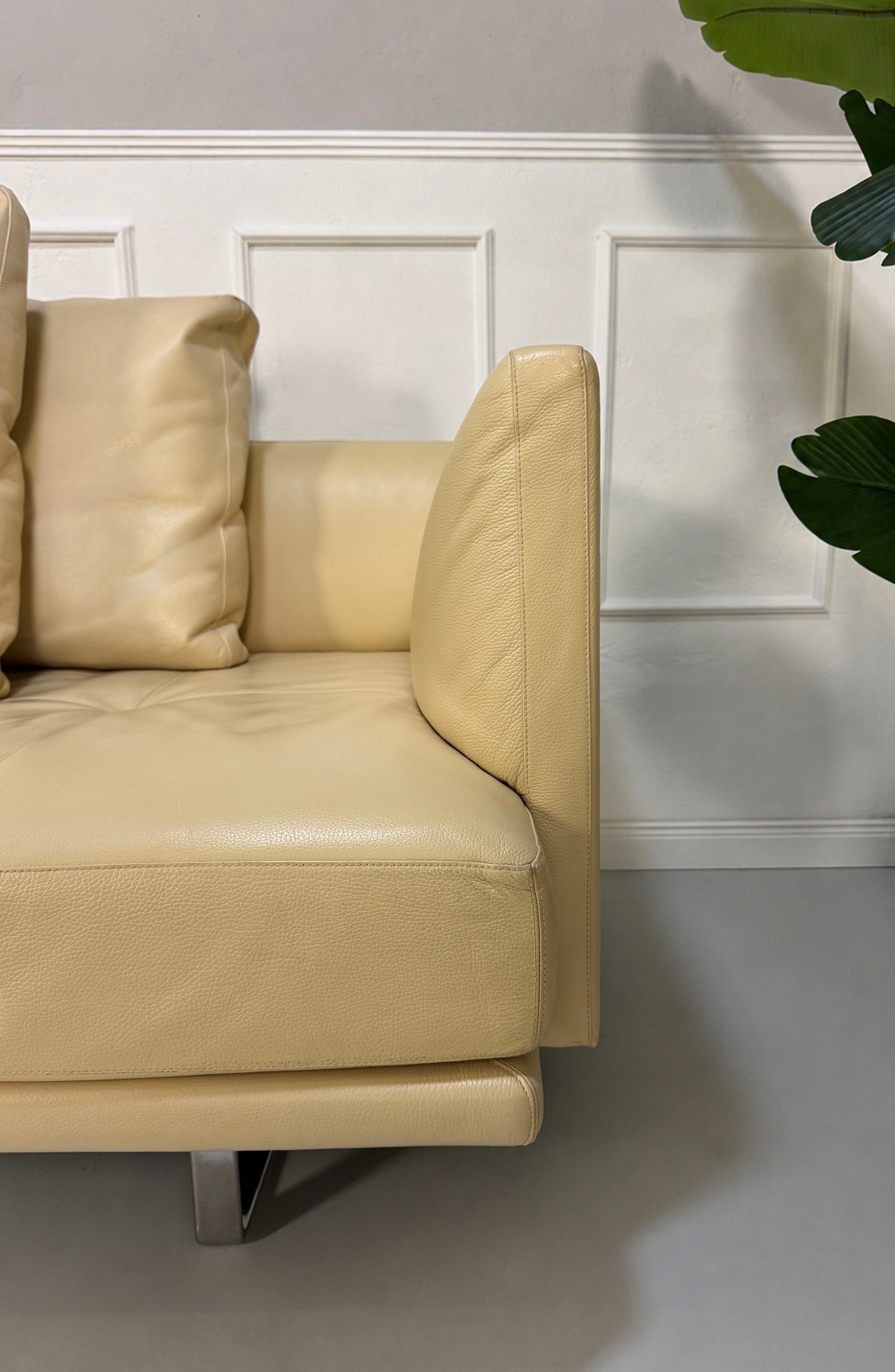 Gebrauchtes beiges Walter Knoll Prime Time Designer Leder Sofa vor einer Wand, stilvoll und modern eingerichtet.
