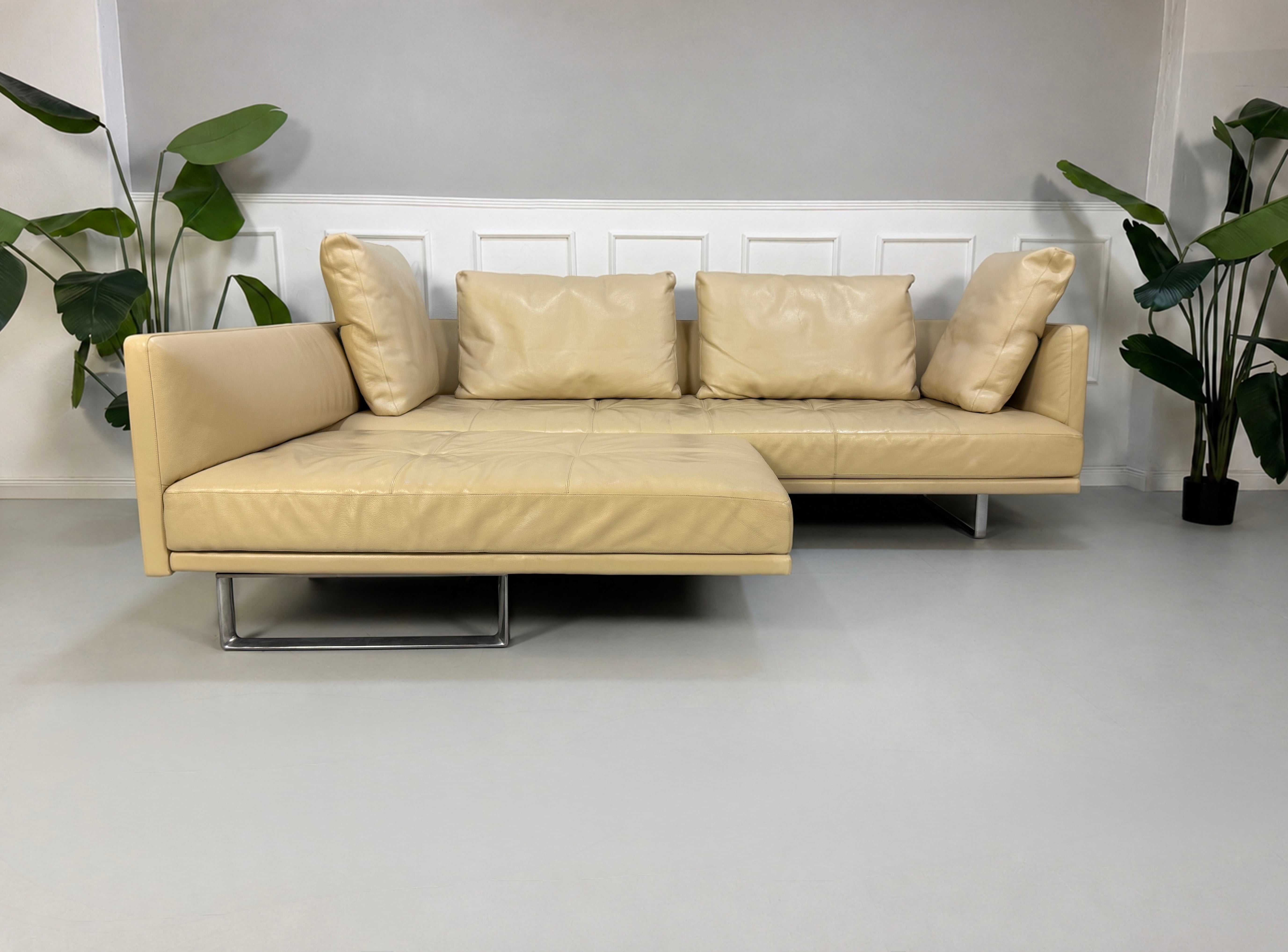 Gebrauchtes beiges Walter Knoll Prime Time Designer Leder Sofa vor einer Wand, stilvoll und modern eingerichtet.