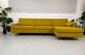Gelbes Ausstellungsstück COR Conseta Designer Stoff Sofa vor einer Wand, stilvoll und modern eingerichtet.