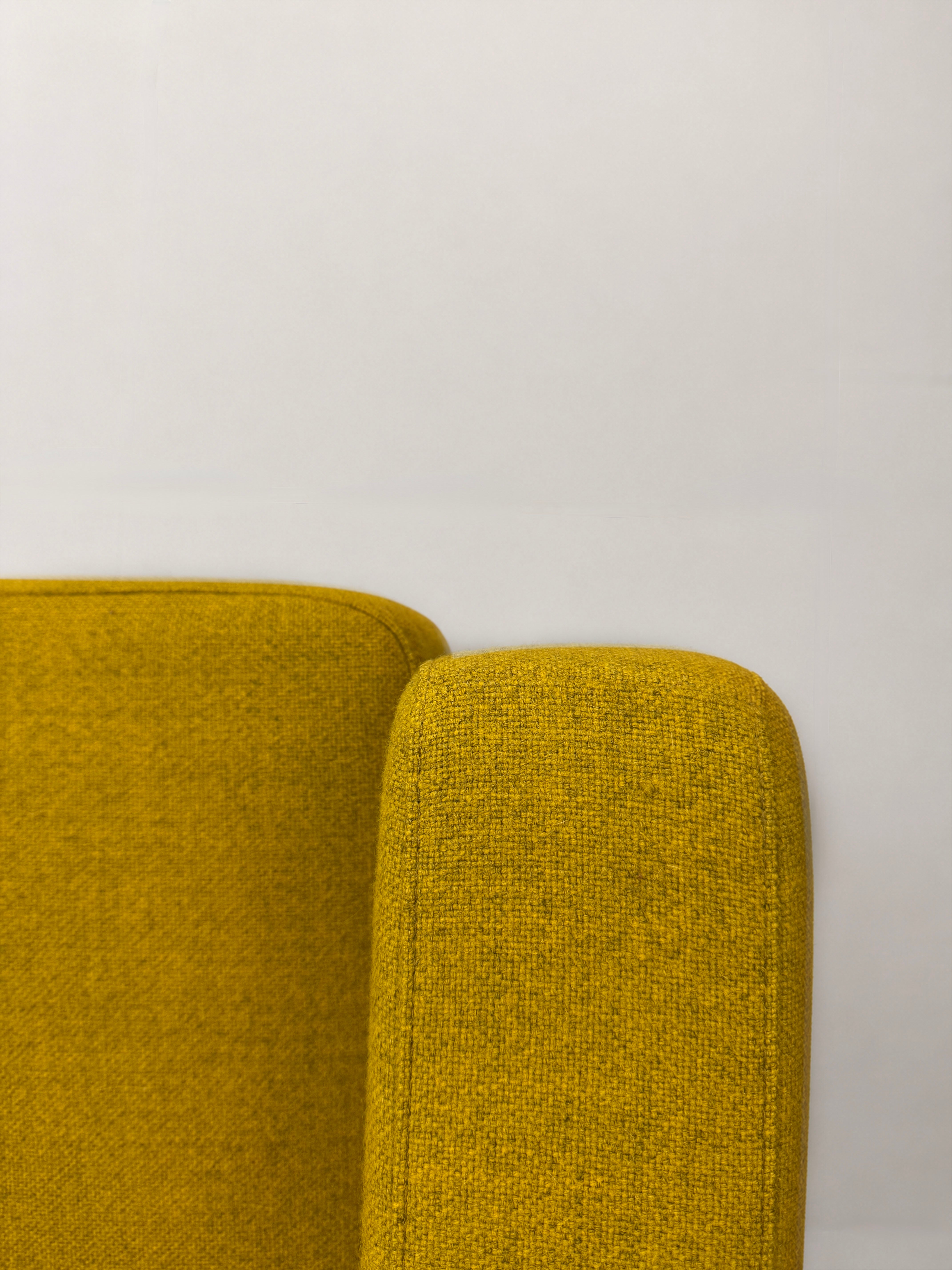 Gelbes Ausstellungsstück COR Conseta Designer Stoff Sofa vor einer Wand, stilvoll und modern eingerichtet.