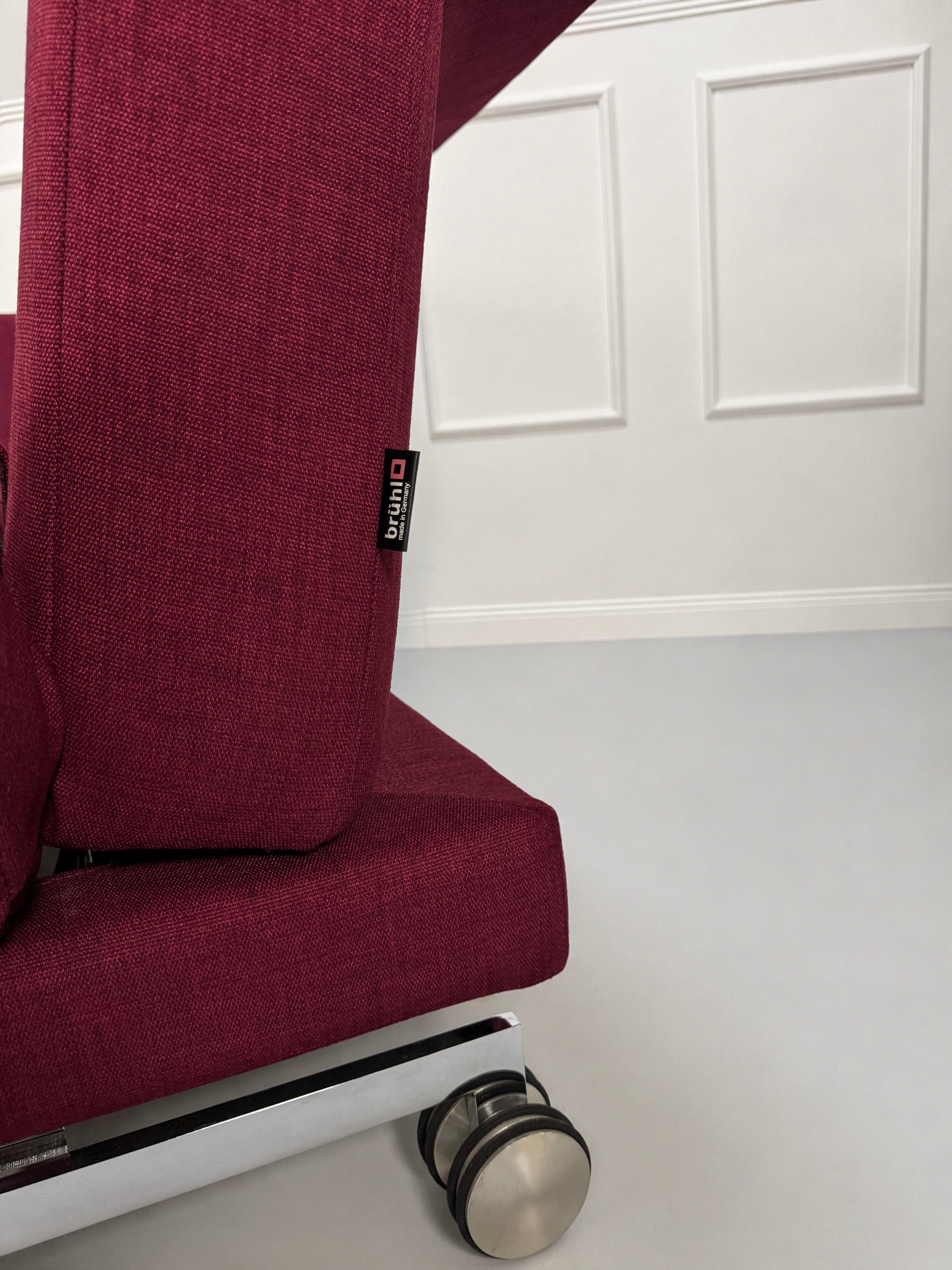 Gebrauchtes rotes Brühl Moule Designer Stoff Sofa vor einer Wand, stilvoll und modern eingerichtet.