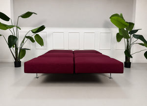 Gebrauchtes rotes Brühl Moule Designer Stoff Sofa vor einer Wand, stilvoll und modern eingerichtet.