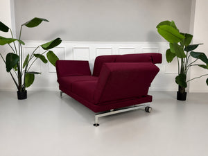Gebrauchtes rotes Brühl Moule Designer Stoff Sofa vor einer Wand, stilvoll und modern eingerichtet.