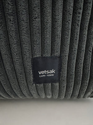 Gebrauchtes graues Vetsak Designer Stoff Sofa vor einer Wand, stilvoll und modern eingerichtet.