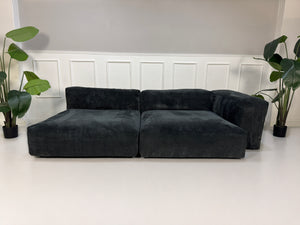 Gebrauchtes graues Vetsak Designer Stoff Sofa vor einer Wand, stilvoll und modern eingerichtet.
