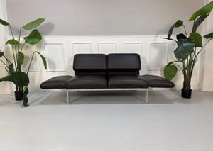 Gebrauchte braune Brühl Roro Designer Leder Sofas vor einer Wand, stilvoll und modern eingerichtet.