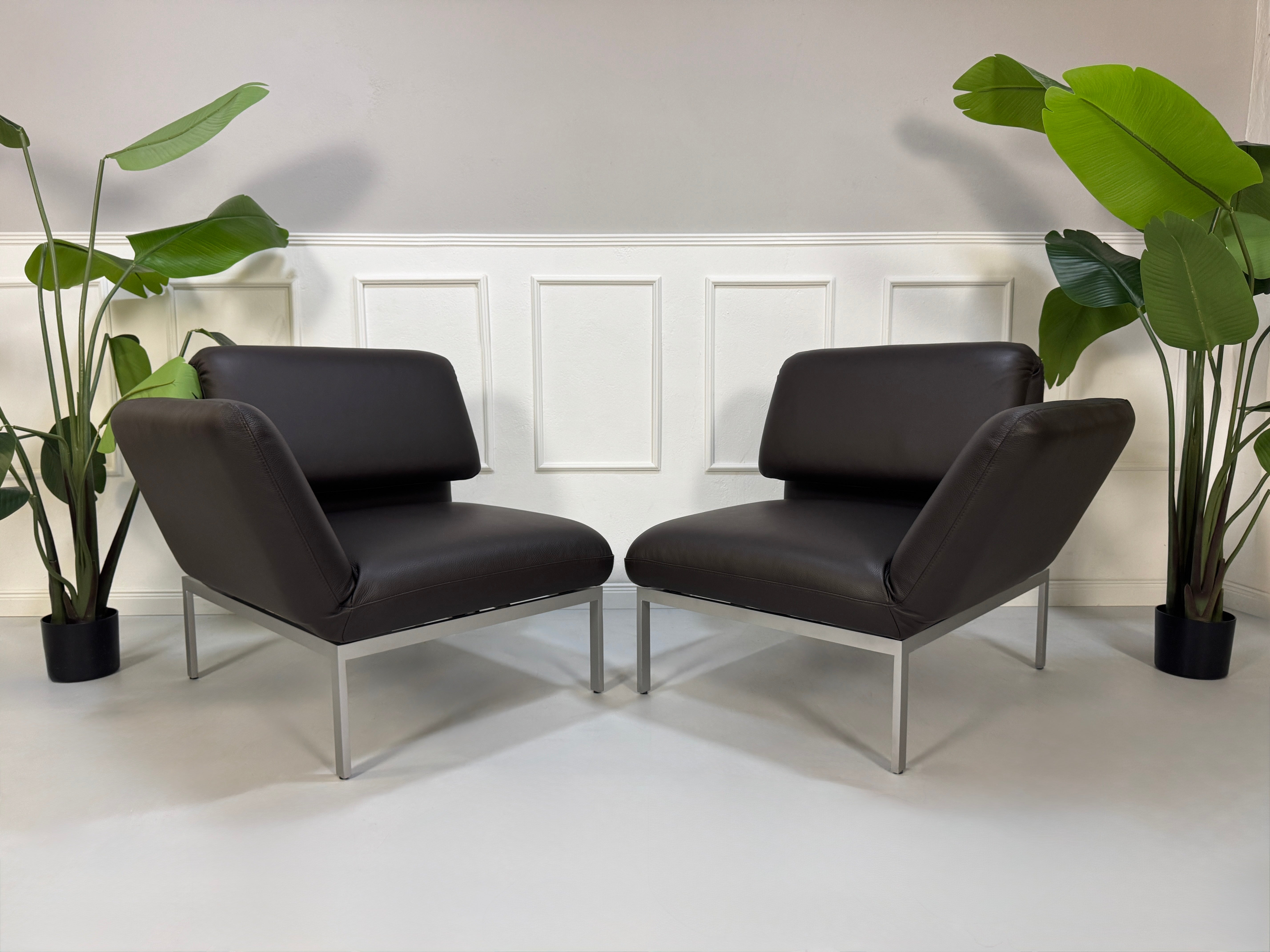 Gebrauchte braune Brühl Roro Designer Leder Sofas vor einer Wand, stilvoll und modern eingerichtet.