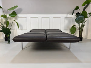 Gebrauchte braune Brühl Roro Designer Leder Sofas vor einer Wand, stilvoll und modern eingerichtet.