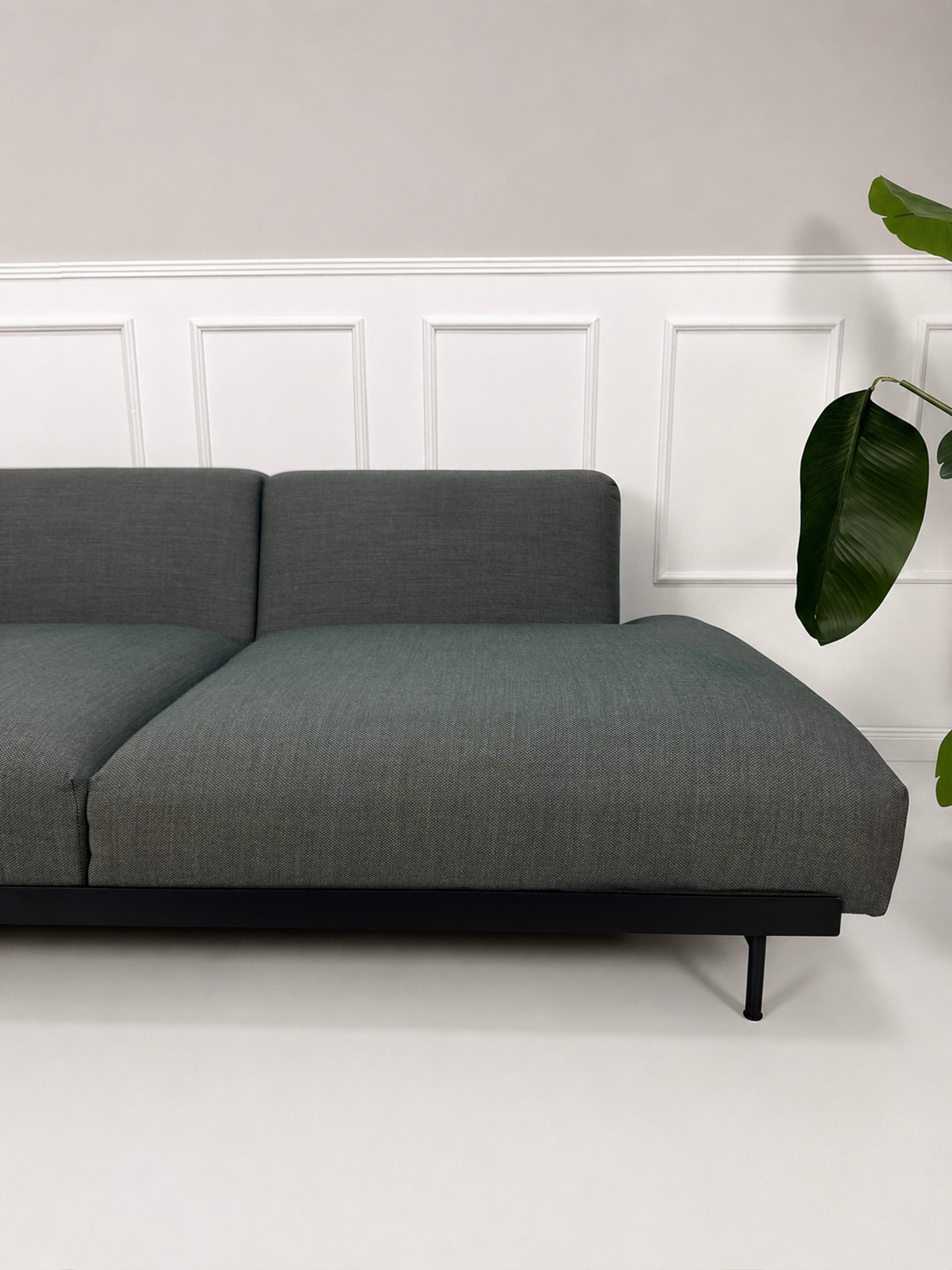 Gebrauchtes graues Muuto In Situ Designer Stoff Sofa vor einer Wand, stilvoll und modern eingerichtet.