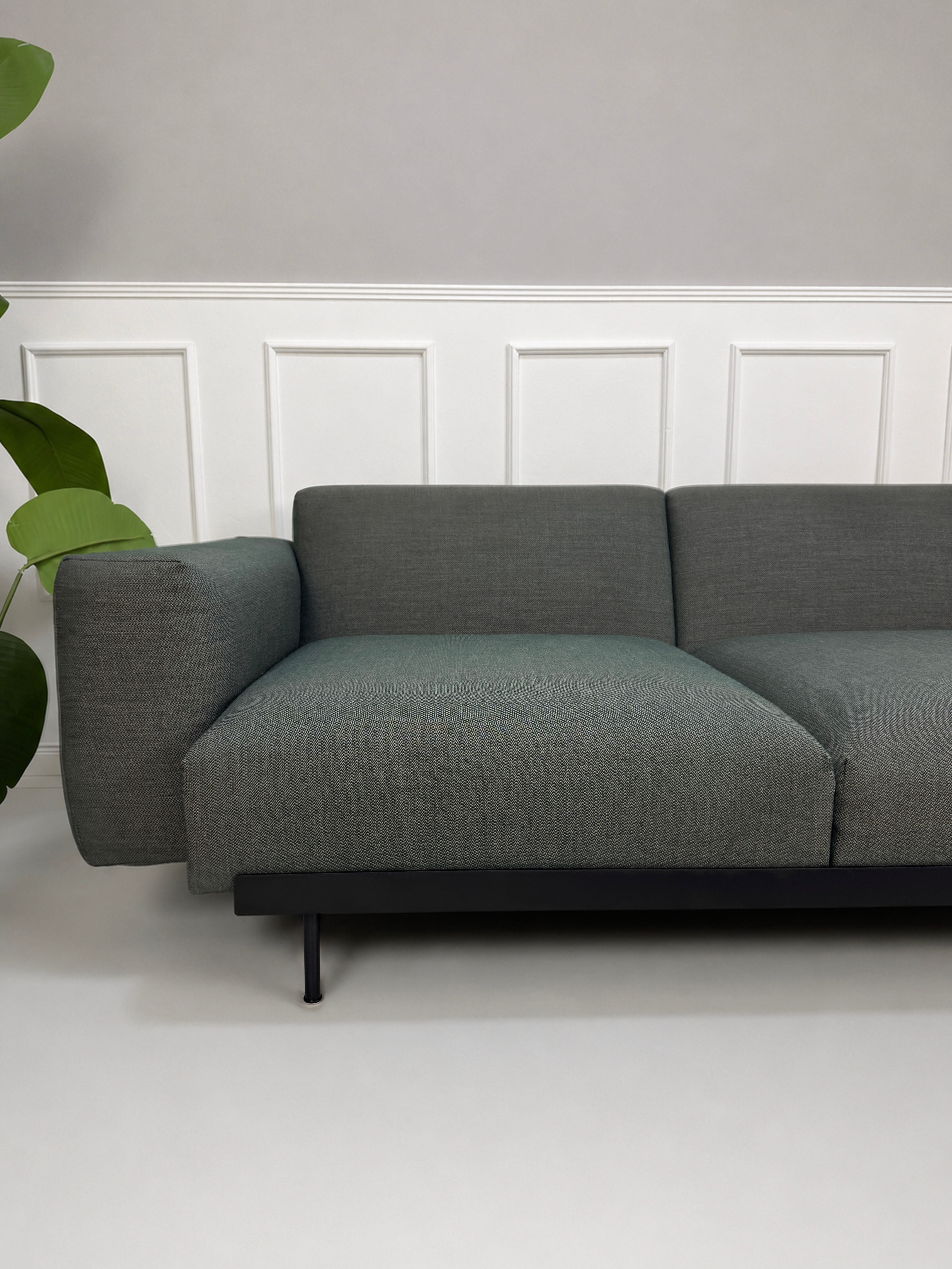 Gebrauchtes graues Muuto In Situ Designer Stoff Sofa vor einer Wand, stilvoll und modern eingerichtet.