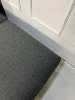 Gebrauchtes graues Muuto In Situ Designer Stoff Sofa vor einer Wand, stilvoll und modern eingerichtet.