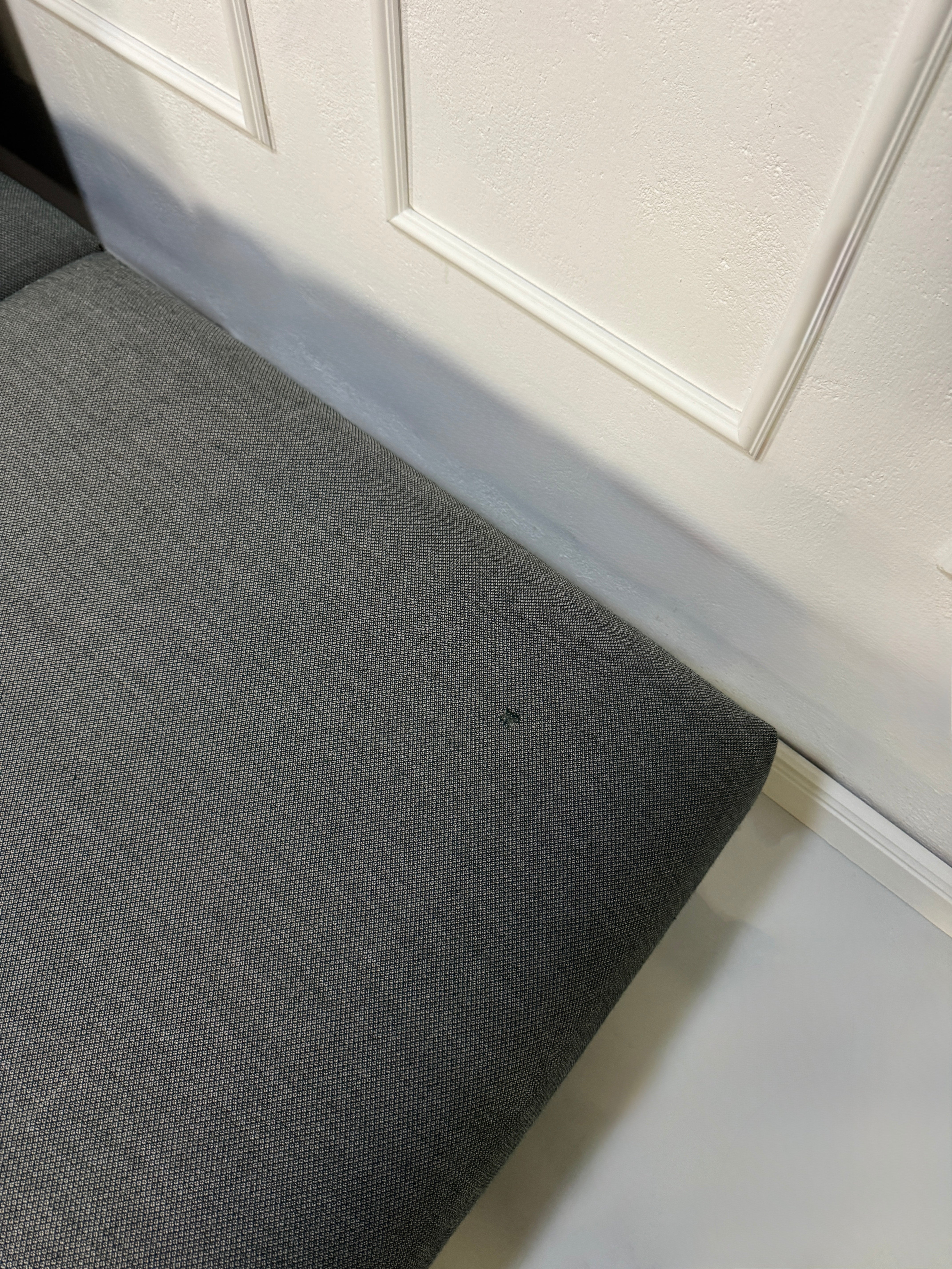 Gebrauchtes graues Muuto In Situ Designer Stoff Sofa vor einer Wand, stilvoll und modern eingerichtet.