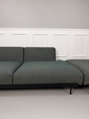 Gebrauchtes graues Muuto In Situ Designer Stoff Sofa vor einer Wand, stilvoll und modern eingerichtet.
