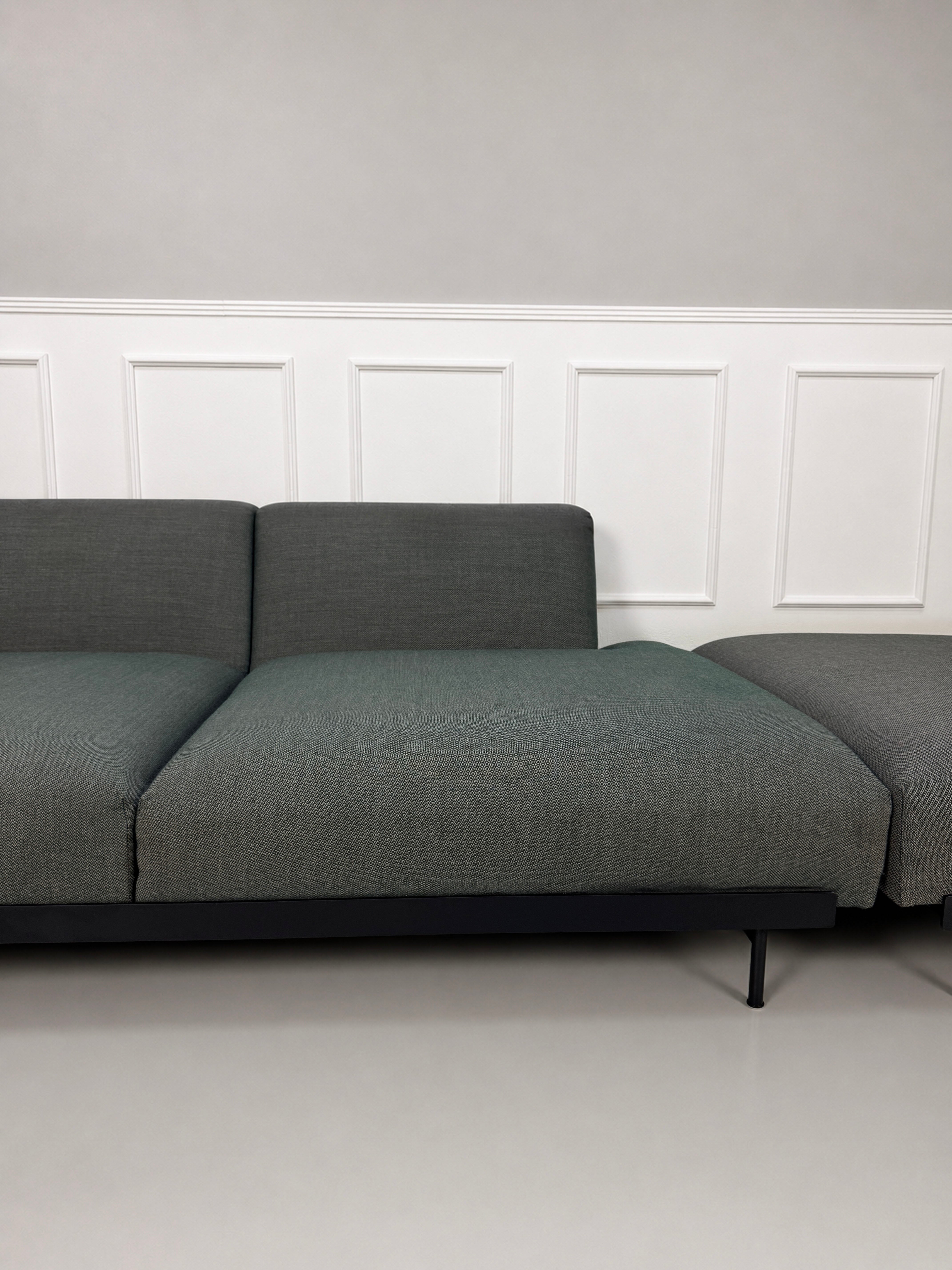 Gebrauchtes graues Muuto In Situ Designer Stoff Sofa vor einer Wand, stilvoll und modern eingerichtet.