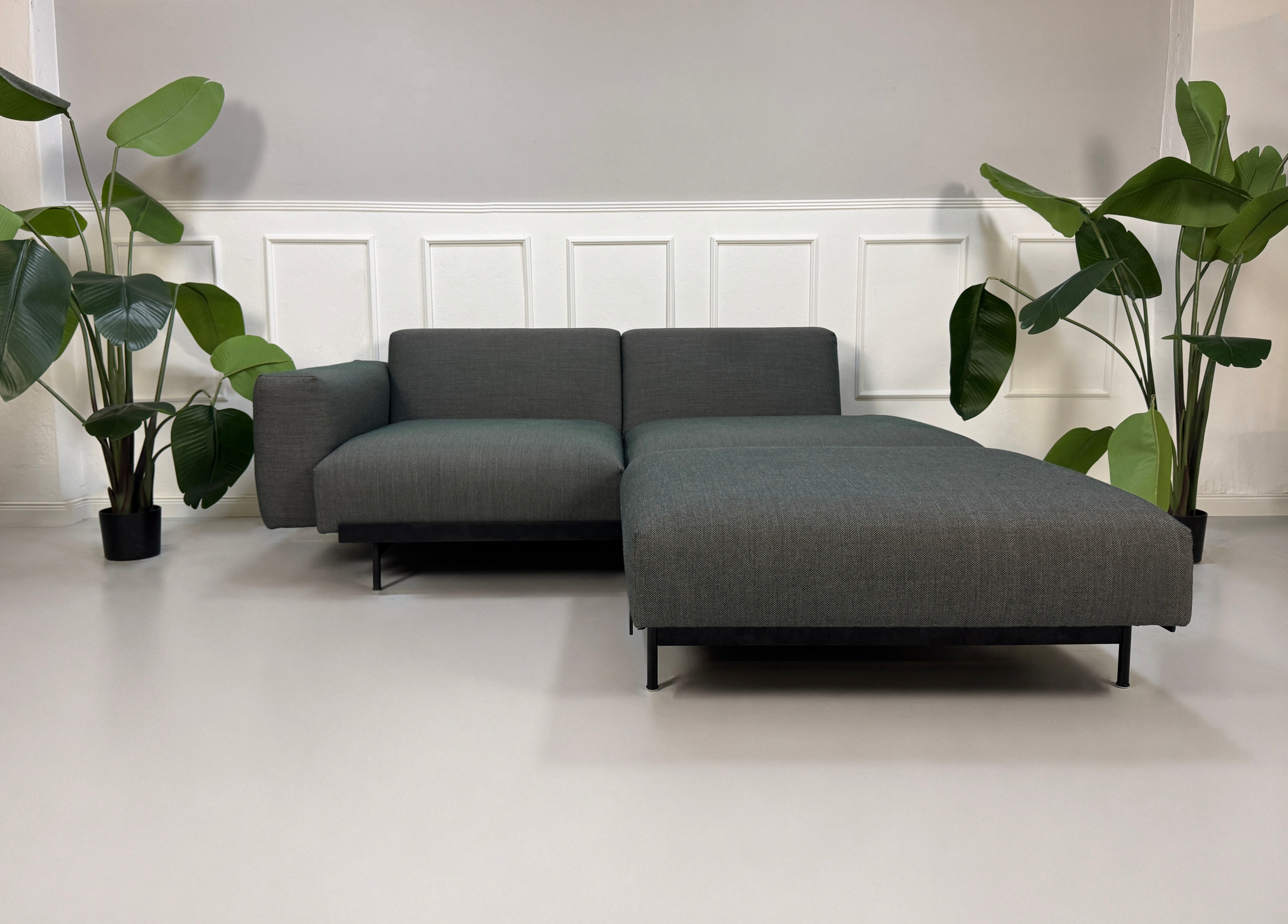 Gebrauchtes graues Muuto In Situ Designer Stoff Sofa vor einer Wand, stilvoll und modern eingerichtet.