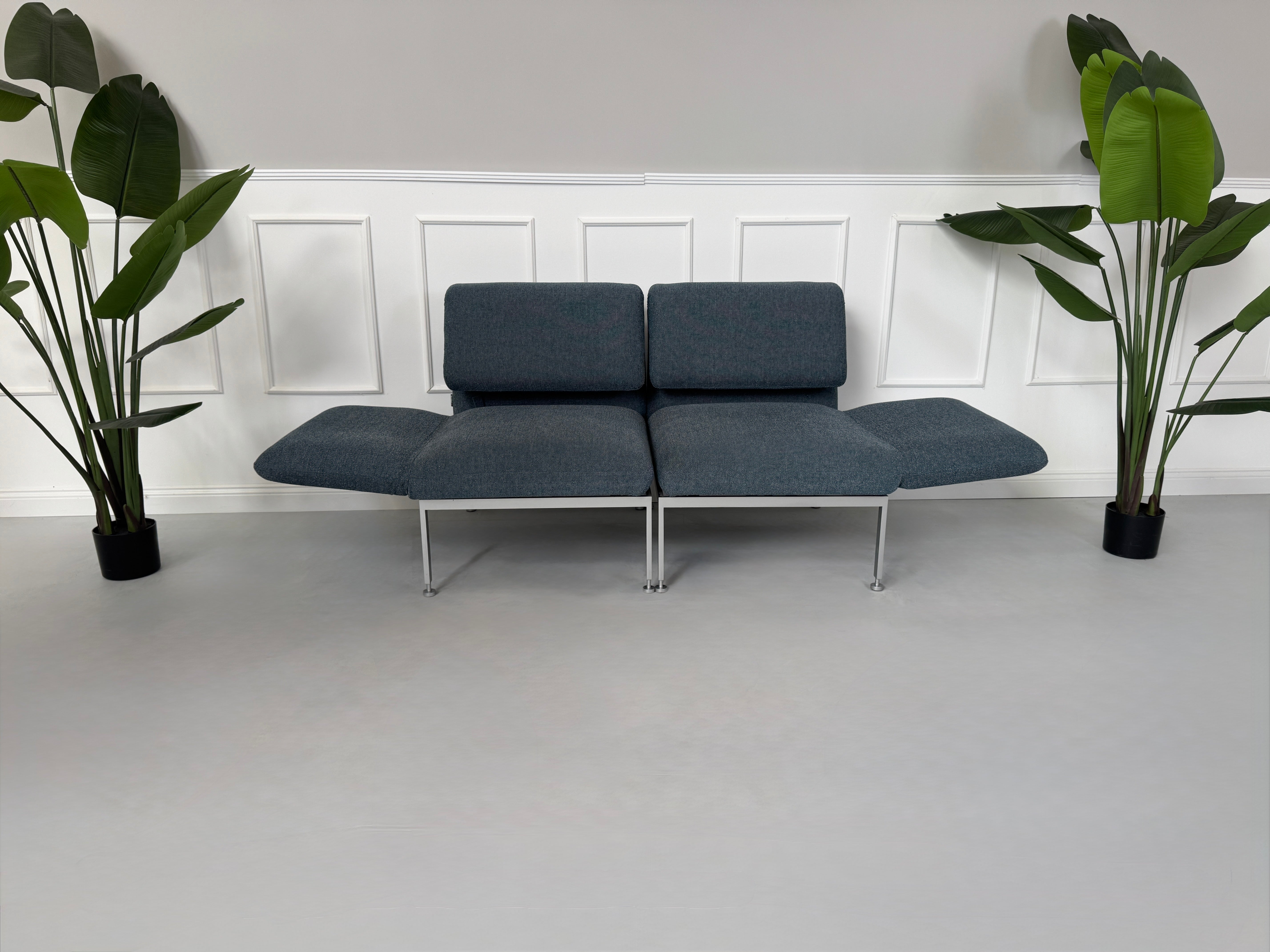 Gebrauchtes grau-blaues Brühl Roro Small Designer Stoff Sofa vor einer Wand, stilvoll und modern eingerichtet.