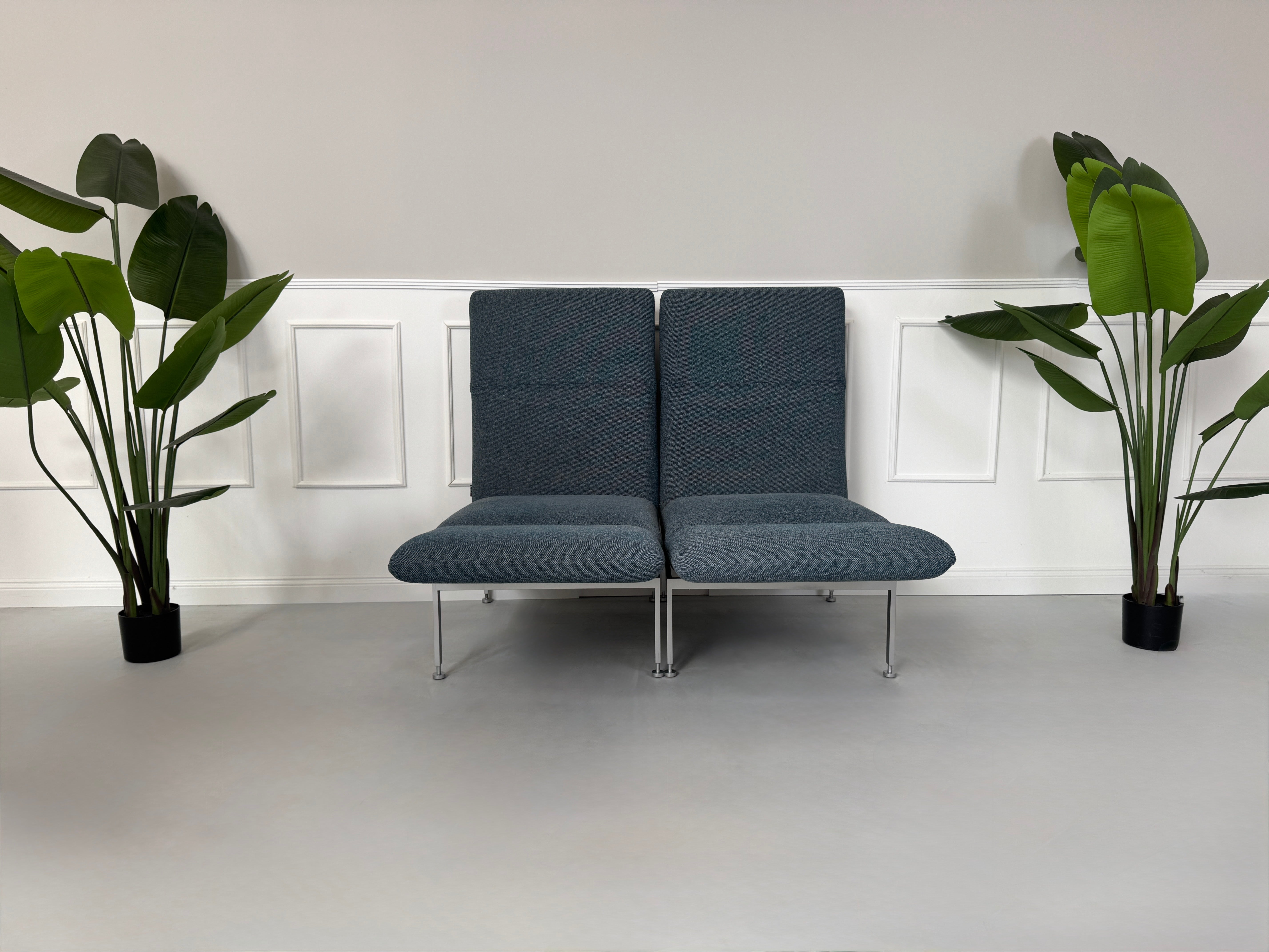 Gebrauchtes grau-blaues Brühl Roro Small Designer Stoff Sofa vor einer Wand, stilvoll und modern eingerichtet.