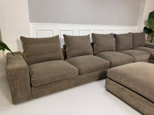 Gebrauchtes braunes Flexform Groundpiece Designer Stoff Sofa vor einer Wand, stilvoll und modern eingerichtet.