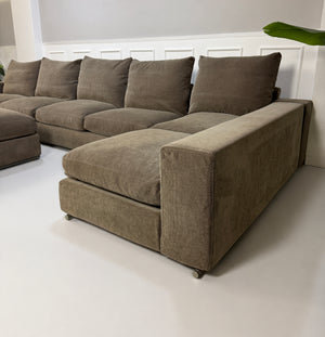 Gebrauchtes braunes Flexform Groundpiece Designer Stoff Sofa vor einer Wand, stilvoll und modern eingerichtet.